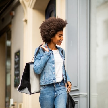 woman carrying shopping bags and looking into store fronts